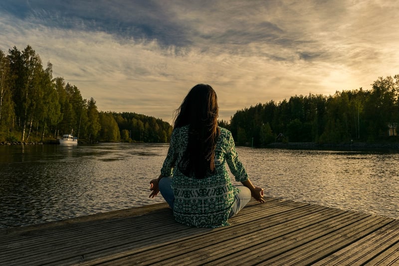 Woman practicing meditation at sunset